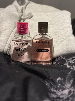 La Rive parfym duo - Två trendiga Eau de Parfum från La Rive: 'Give Me Love' med rosa detaljer och 'Charisme' med elegant design. Perfekt för dig som vill ha en modern och ungdomlig touch i din parfymkollektion.