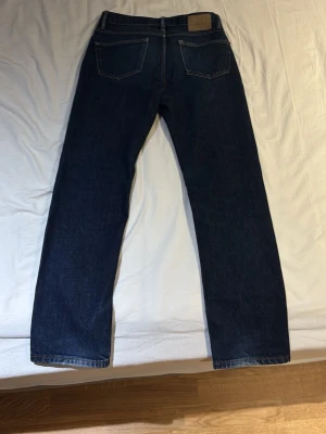 Mörkblåa jeans från Lager157 - Mörkblå Levi's 517 jeans med klassisk straight fit och fyra fickor. Jeansen har en hög midja och är tillverkade i slitstarkt bomullsjeansmaterial. Snygga kontrastsömmar och Levi's patch baktill. Perfekta för dig som gillar tidlös denimstil.
