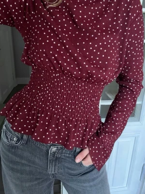 Vinröd prickig blus - Jätte fin vinröd tröja med prickar från Gina tricot. Markerad midja.