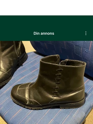 Svarta boots i skinn med dragkedja - Säljer ett par svarta boots i skinn med robust sula och dragkedja på sidan. Skorna har fyrkantig tå och markerade sömmar som ger en cool look. Passar perfekt till höst och vinter för dig som gillar stilrena men tuffa skor. Säljs på fler sidor. Köparen betalar frakt.