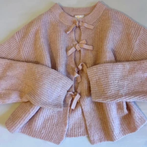 Gina Tricot Rosett Rosa Kofta 🎀 Coquette - Gina Tricot Mjuk Rosa Kofta – Coquette 🌸 🌸 Supermjuk stickad kofta med mysig och varm känsla 🎀 Feminin rosettstängning som ger en romantisk coquette-look 🌸 Perfekt balans mellan gullig och elegant 🎀 Fantastiskt skick 🌸 Kvalitetsmaterial: 14% ull, 7% alpacka m.m. 🎀 Storlek 170, passar som XS/S Perfekt för: 🌸 Mjuka vardagsoutfits 🎀 Coquette / balletcore-stil 🌸 Över klänningar eller toppar för lager-på-lager-look 🎀 Mysiga men ändå feminina outfits 