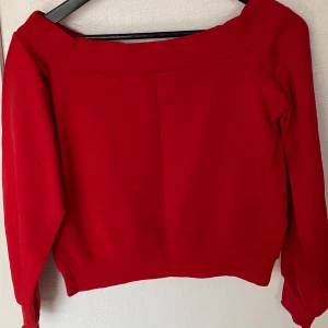 Röd offshoulder topp från Divided - Säljer en snygg röd offshoulder topp från Divided, H&M. Modellen är croppad med långa ärmar och bred kant upptill som ger en cool offshoulder-look. Mjuk och skön polyester som känns bekväm mot huden. Perfekt för dig som gillar att sticka ut med färg.
