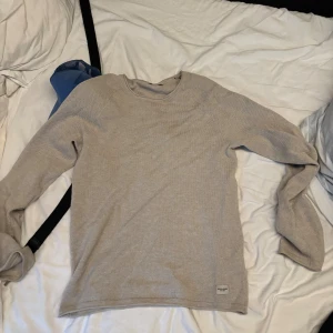 Beige stickad tröja från Jack & Jones (Pris ej huget i sten) - Säljer en stilren beige stickad tröja från Jack & Jones i storlek XS. Tröjan har rund halsringning och lång ärm, perfekt för lager-på-lager. Mjuk och skön känsla, passar till jeans eller chinos.