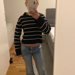 Svartvit randig stickad tröja H&M - Säljer en svart stickad tröja från H&M med vita horisontella ränder. Tröjan är croppad med lång ärm och har en loose passform. Perfekt för dig som gillar en chill och trendig stil.