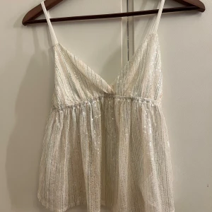 Fest top från subdued  - Säljer en superfin glittrig vit linnetopp med tunna axelband och v-ringad front. Köpte den för runt 450 kr i somras och den är aldrig använd. Om man har någon fråga så är det bara att skriva! ☺️Pris går att diskuteras 