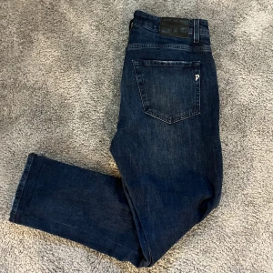 Dondup jeans - Säljer ett par äldre dondup jeans. Storleken är 32/32 och dem är slim fit och alltså inte skinny. Färgen är mörkblå