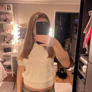 Vit kortärmad topp från Zara - Säljer en stilren vit topp från Zara i storlek S. Toppen har korta ärmar, rund halsringning och är gjord i ett mjukt material, säljer då den är för liten för mig! Men skit snygg då den sitter lite taightare mot kroppen!!💞