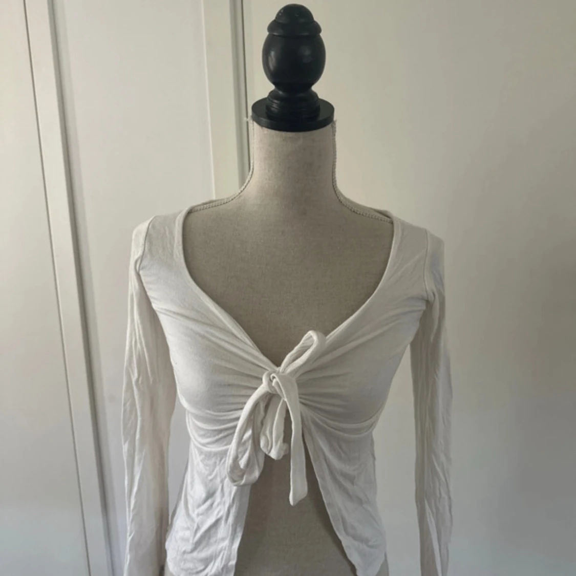 Vit långärmad bolerotopp med knyt