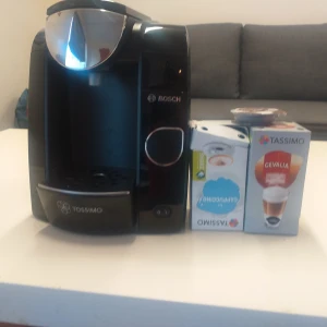 Tassimo Kaffemaskin - Snygg och välfungerande Tassimo kaffemaskin från Bosch. Maskinen är i gott skick och levereras med kapslar för direkt användning. Perfekt för snabb och enkel bryggning av kaffe och cappuccino. Inga synliga defekter eller större slitage.