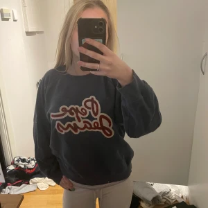 Mörkblå sweatshirt från Pepe Jeans - Säljer en mörkblå sweatshirt från Pepe Jeans med stor röd och vit logga framtill. Tröjan har rund hals, ribbade muddar och är långärmad. Perfekt för en chill och avslappnad stil.