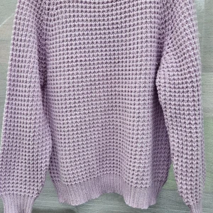 Ljuslila stickad tröja från 157, stl L - Supermysig ljuslila stickad tröja från 157 med grov struktur och ribbade muddar. Perfekt för lager-på-lager och chill dagar. Tröjan har lång ärm och en loose fit som ger en avslappnad vibe