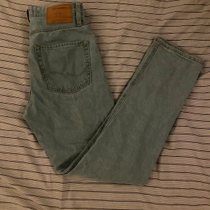 Ljusblå jeans från Jack & Jones - Säljer ett par ljusblå jeans från Jack & Jones med klassisk femficksdesign och rak passform. Jeansen har en snygg vintagekänsla och är tillverkade i mjukt denimtyg. Perfekta för dig som gillar en enkel och stilren look. 27/32
