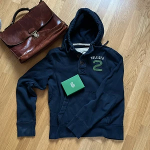 Hollister Hoodie - Säljer nu en ovanlig mörkblå hoodie med knappar från Hollister i mycket bra skick❤️Var inte rädd för att ställa fler frågor✌️