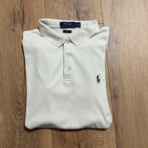 Ralph Lauren Piké - Säljer denna stilrena och klassiska vita Ralph Lauren pikén. Pikén är ett lite mer sportigt material så passar perfekt för exempelvis golfrundan eller tennis, men fungerar lika bra för att klä upp sig inför en finmiddag. Storlek M slim men sitter som en S. Har du några frågor? Tveka inte att höra av dig. Allt gott från Deluxe garderoben ⭐️ 