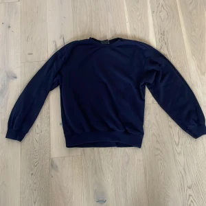 Mörkblå sweatshirt från H&M XS - En enkel och stilren mörkblå sweatshirt från H&M i relaxed fit. Tröjan har rund hals och långa ärmar. Perfekt för lugna dagar och passar till allt. Materialet är mjukt och känns skönt mot huden. Säljer då jag växt ur den.