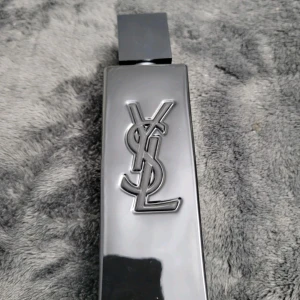 YSL MYSLF Eau de Parfum 100ml oanvänd  - Stilren parfym från Yves Saint Laurent med modern design. Flaskan har YSL-loggan och kartongen visar namnet MYSLF. Perfekt för dig som vill sticka ut med en ikonisk doft från ett välkänt modehus.