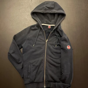 Colmar Tröja Mörkblå - Mörkblå tröja med dragkedja från Colmar.- Ny pris: 1300 kr - Vårt Pris: 400 Kr - Storlek: XS men sitter mer som S - Först till Kvarn!