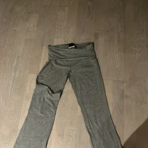 Grå yogapants från Gina tricot  - Säljer ett par grå yogapants från gina tricoti storlek XXS. Byxorna är lågmidjade med bred linning och raka ben, perfekta för chill dagar. Materialet är mjukt och stretchigt för extra komfort. Snygga att matcha med en hoodie eller crop top.