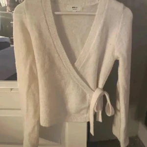 Vit omlottkofta med knyt - Storlek S. Vit kofta från Gina!