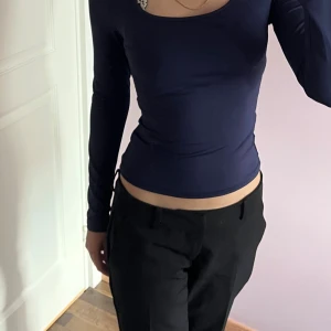 Mörkblå långärmad topp - Snygg mörkblå långärmad topp med tight passform och rundad halsringning. Materialet är mjukt och stretchigt, perfekt för dig som gillar en enkel men stilren look. Toppen är figurnära och passar dig som vill ha en smickrande siluett.