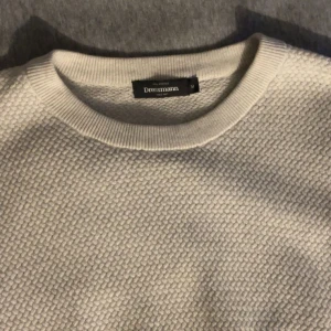 Vit stickad tröja från Dressmann - Säljer en stilren vit stickad tröja från Dressmann i storlek M. Tröjan har ett snyggt strukturerat mönster, rund hals och långa ärmar. Perfekt för dig som gillar enkel och clean stil. Passar dig som vill ha en normal passform och mjukt material.