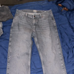 Grå jeans från Dressmann  - Säljer ett par grå jeans från Dressmann i klassisk rak modell. Jeansen har fem fickor, knapp och dragkedja fram samt bälteshällor. Materialet är slitstarkt denim och färgen är ljusgrå med lite tvättad look. Perfekt för dig som gillar enkel och stilren design.
