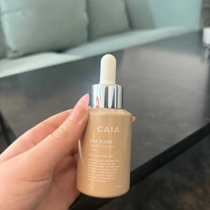 CAIA Silk Elixir serum med pipett - CAIA Silk Elixir Length Serum i beige glasflaska med silvrig pipett. Innehåller hyaluronsyra och mjölksyra för återfuktning och glans. Snygg och stilren design, perfekt för dig som gillar lyxiga produkter i badrumshyllan. Använt en gång