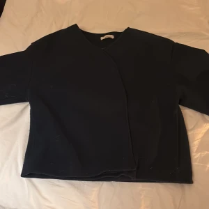 Mörkblå kofta från Gina Tricot - Snygg mörkblå kofta från Gina Tricot i premiumkvalitet. Koftan har lång ärm, omlott-design och stängs med stora knappar framtill. Materialet känns mjukt och lite tjockare, perfekt för kyliga dagar. Enkel och stilren look som funkar till många outfits.