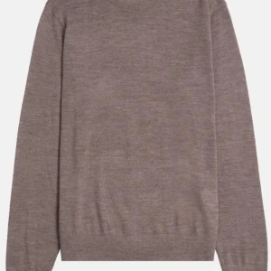 Beige stickad tröja i ull - En stilren beige stickad tröja med rund hals och långa ärmar. Tröjan är tillverkad i mjuk ull och har en klassisk passform som funkar perfekt till jeans eller kjol. Enkel och tidlös design som passar till många olika looks.