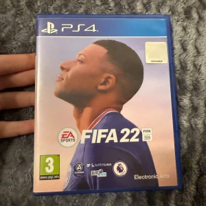 FIFA 22 PS4 - FIFA 22 till PlayStation 4 i originalfodral. Skivan och omslaget är i mycket gott skick, utan synliga repor eller skador. Upplev realistisk fotboll med officiella ligor och lag. Perfekt för både solo- och multiplayerspel. PEGI 3. 