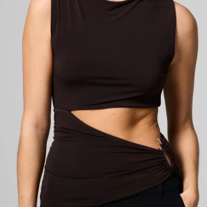 Brun asymmetrisk topp - Säljer en brun topp från Bik Bok med cool asymmetrisk cut-out. Perfekt för dig som gillar trendiga och unika plagg.