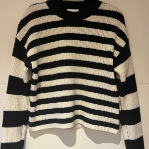 Randig stickad tröja från Monki XS - Säljer en mörkblå randig stickad tröja från Monki i storlek XS. Tröjan har breda horisontella ränder, rund halsringning och långa ärmar. Materialet är en mix av polyester, akryl och ull vilket gör den både mjuk och varm. Perfekt för lager-på-lager-stil. Säljer även en likadan med röda ränder istället för blå. 