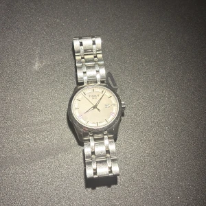 Tissot 1853 sapphire crystal classic dream - En stilren silver klocka i tissot som nästan är sprillans ny. En riktigt snygg tissot box ingår samt en tissot bok som innehåller hela tissots historia, den finns i ett fack på baksidan av boxen. Det är ett silverarmband och klockan har en fin vit framsida. Den är i rostfritt stål och är vattentät 10 bar (100 m) . Diameter 42mm. Min handled är 16 cm och den sitter perfekt. Pris går att diskuteras.