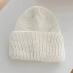 Vit ribbad stickad mössa - Snygg vit mössa med ribbad struktur och uppvikt kant. Perfekt för kalla dagar och enkel att matcha med olika outfits. Mjuk och skön stickad känsla. Pm om pris inte passar dig!