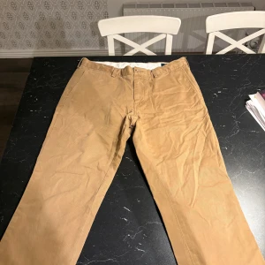 Beiga chinos från Polo Ralph Lauren - Knappt använda ser ut som nya. riktigt snygga passar till allt! Inte många som har såna byxor. säljs knappt längre denna typ av byxor!