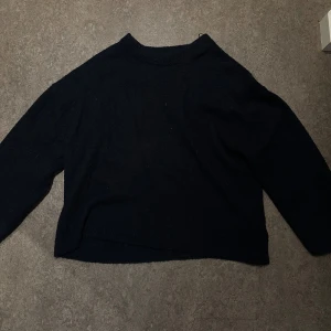 Mörkblå stickad tröja från Gina  - En mörkblå stickad tröja med lång ärm och rund hals. Tröjan har en rak passform. Den ser mörkare ut på bilden än vad den faktiskt är. Superskön o ha och är varm! Från Gina Tricot i storlek XL. Säljer för 90kr