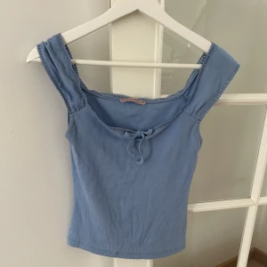 Blå ribbad linnetopp från Anna Field - Supersöt ljusblå ribbad linnetopp från Anna Field med breda axelband och knytning framtill. Använd ett fåtal gånger.