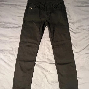 Svarta Diesel jeans straight fit - Svarta jeans från Diesel med klassisk femficksdesign och raka ben. Snyggt diskret Diesel-märke på fickan och patch bak i midjan. Jeansen är i ett robust bomullsmaterial och har en stilren look som passar till det mesta.