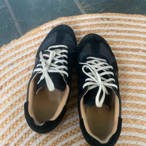 Svarta sneakers från Oliver Cabell - Snygga svarta sneakers från Oliver Cabell med beige sula och vita snören. Ovandelen är i en mix av skinn och mocka. Storlek: 43 , mycket bra skick, inga defekter eller skador! Pris: 1299 (förhandlingsbart!) Tveka inte att höra av er efter fler bilder eller prisförslag!