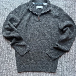 Grå stickad tröja från Pier One - Mysig mörkgrå stickad tröja från Pier One med ribbad krage och half zip-dragkedja. Tröjan har långa ärmar och breda muddar vid ärmslut och nederkant. Perfekt för kyliga dagar och enkel att matcha med jeans eller chinos. Skickar inom 1-2 dagar🙌. Svarar snabbt så tveka inte på att höra av er vid frågor och funderingar😄kom gärna med prisförslag så kan vi säkert lösa något som funkar för båda😄
