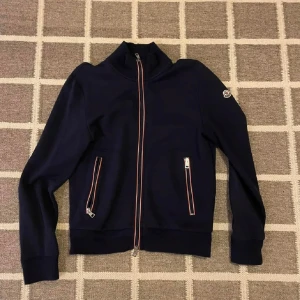 Mörkblå Moncler med dragkedja - Size M men passar S. Bra skick, sparsamt använd.