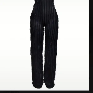 Svart randig byxdress med struktur - Snygg svart byxdress med raka ben och markerad midja. Tyget har en cool randig struktur som ger en unik look. Perfekt för dig som vill sticka ut med en trendig och stilren outfit. 