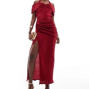 Vinröd långklänning i manchester - Snygg vinröd långklänning i mjuk manchester med offshoulder och knyt i midjan. Klänningen har en slits på sidan och smickrande drapering över höfterna. Perfekt för dig som vill sticka ut med en cool och trendig look.