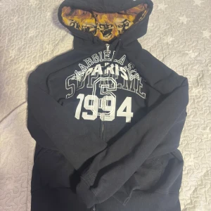 Supreme Maison Margiela Zip Up - Supreme Maison Margiela zip up. Detta är en K0P1A så bra som det kommer. Matrialen är riktigt bra och känns exakt som r1ktiga. Riktigt varm och skön tröja. Säljs Pga kom inte till använding. Sitter som riktiga👍. Bara att skriva om ni undrar nått mer