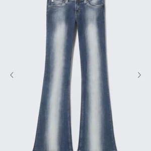 Blå bootcut jeans med blekta detaljer - Snygga blå bootcut jeans med tydliga blekta partier längs benen. Klassisk femficksmodell med låg midja och utsvängda ben. Perfekta för dig som gillar retrovibbar och vill sticka ut med en cool siluett. har ett hål längst ner på ena benet, ni kan be om bild på det