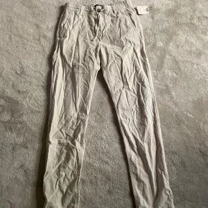 Beige linnebyxor från Hampton Republic - Snygga beige linnebyxor från Hampton Republic med elastisk midja och dragsnören. Byxorna har raka ben, sidofickor fram och passpoalfickor bak. Tillverkade i mjuk bomull, perfekta för en avslappnad och stilren look. Hör av dig vid frågor😁