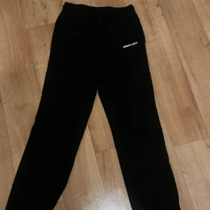 Svarta, gråa och cream vita mjukisbyxor - Två par mjukisbyxor, ett par svarta från Axel Arigato med vit textdetalj 'ARIGATO ©2014' , samt ett par vita från Lounge med broderad logga och grov snörning. Båda har relaxed fit och är perfekta för chill dagar.De sista gråa är oversized mjukisar från missguided 300kr/st