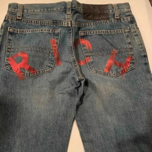 John Richmond bootcut jeans - Snygga bootcut jeans med 'RICH' målad över bakfickorna.😍 superbra skick, 78cm midjemått. Köpta på Vestiaire