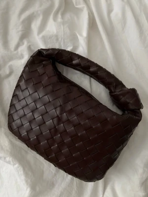 Mörkbrun flätad handväska  - Extremt fin brun handväska som är helt oanvänd. Ej äkta, dust bag följer med. Kvitto finns ej🤎