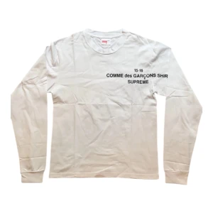  Supreme x Comme des Garçons Longsleeve - Vit långärmad t-shirt från Supreme och Comme des Garçons med svart tryck på bröstet.                                        Längd: 66cm                                                                                Axlar: 45cm                                                                                 Bröst: 47cm                                                                                 